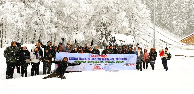 Grup perjalanan Ruhens memegang spanduk di lanskap hutan bersalju.