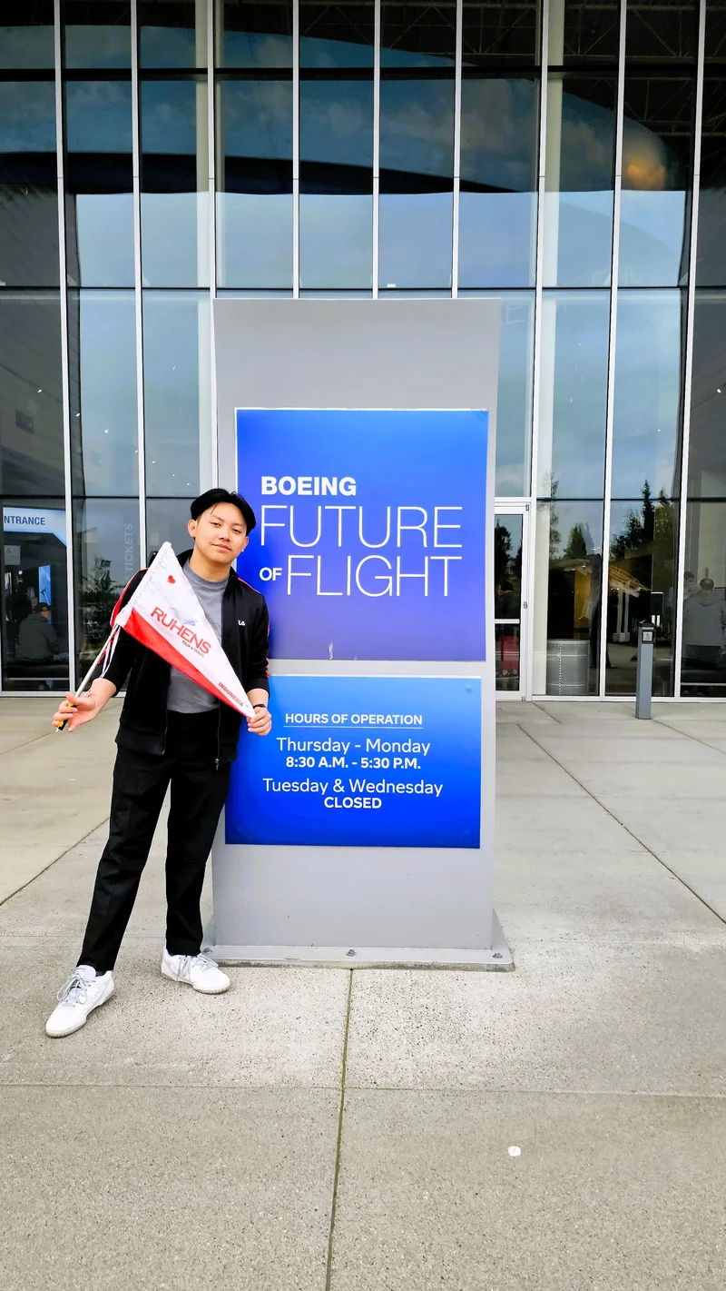 Seorang peserta memegang bendera Ruhens di samping papan Boeing Future of Flight di kawasan Seattle.